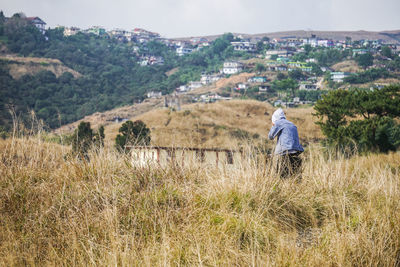 Rear view of man on field against blue sky