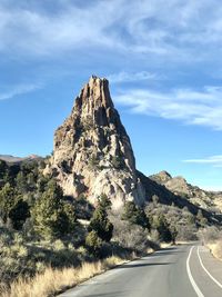 Road by rock formation against sky