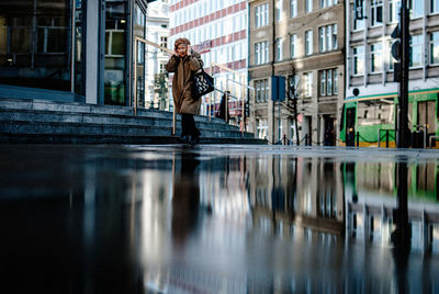 People on street by canal in city