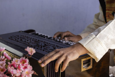 Selective focus on human hand playing harmonium - indian classical instruments