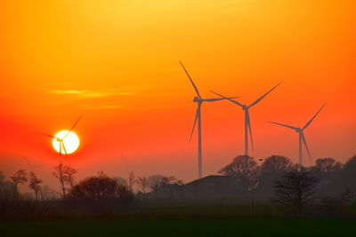 Scenic view of sunset with windmills in the background