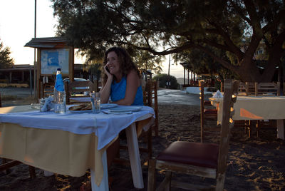 Portrait of woman sitting on chair at outdoor cafe