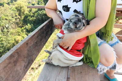 Midsection of woman with dog sitting on bench