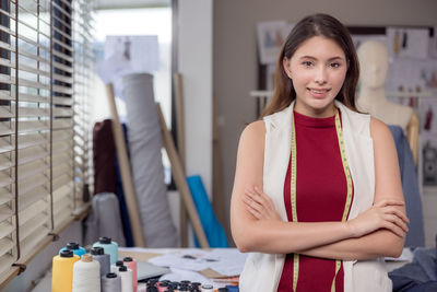 At work, a portrait of a smiling fashion designer and a creative woman is taken.