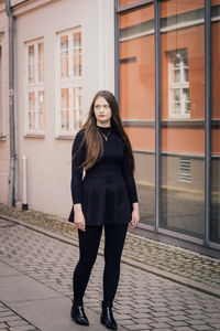 Portrait of young woman standing in city