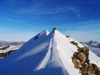 Snow covered mountain against blue sky