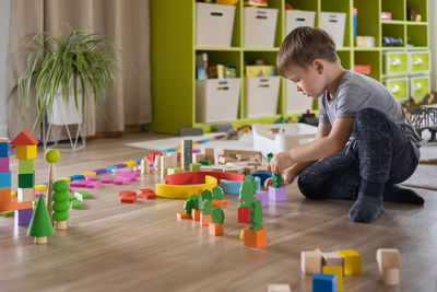 Side view of boy playing with toys