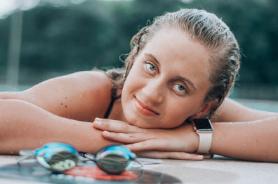 Portrait of woman lying on swimming pool