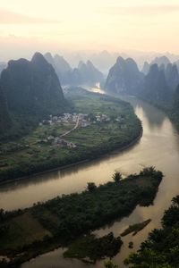 Scenic view of river and mountains against sky