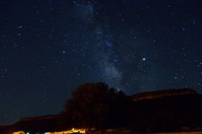 Low angle view of silhouette trees against sky at night