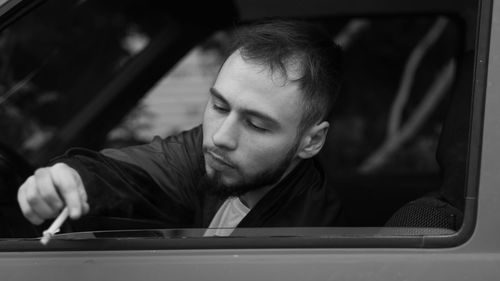 Portrait of young woman sitting in car