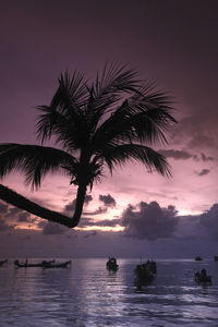 Silhouette people at beach against sky during sunset