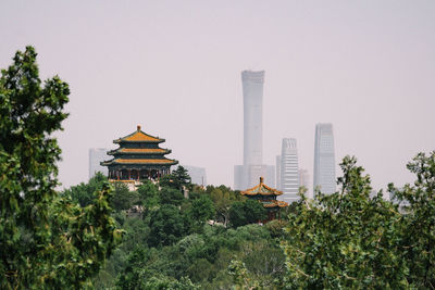 Panoramic view of trees and buildings against sky