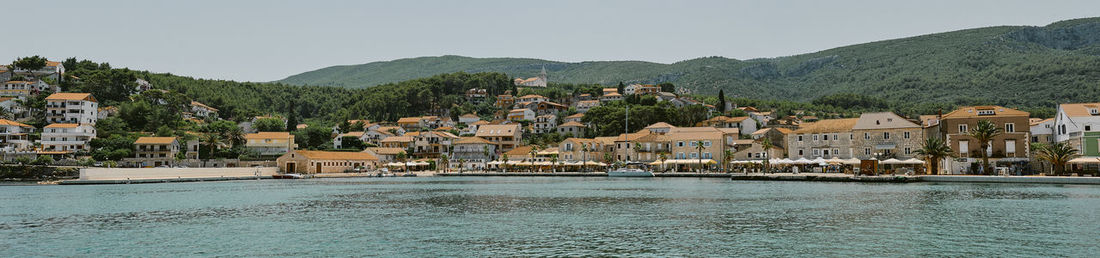 Scenic view of townscape by sea against sky