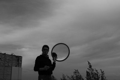 Low angle view of man standing against sky