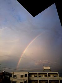 Low angle view of rainbow against cloudy sky