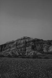 Scenic view of land and mountains against clear sky