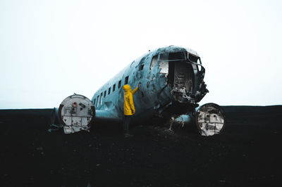 Abandoned airplane on field against clear sky