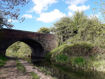 Arch bridge over river against sky