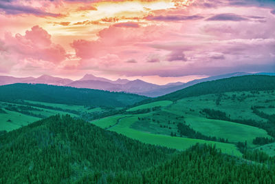 Scenic view of farm against sky during sunset