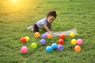 Cute baby boy playing on grassy field at park during sunset