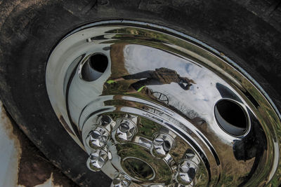 High angle close-up of woman reflecting on wheel rim