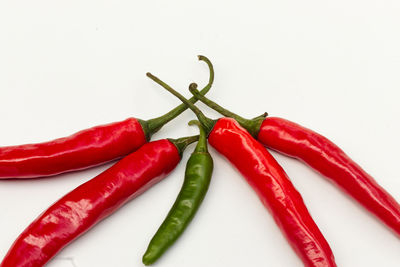 Close-up of red chili peppers against white background