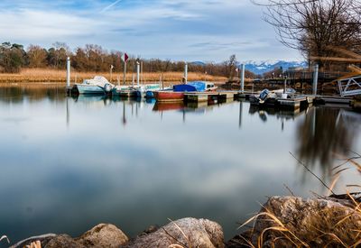 Boats moored in lake against sky