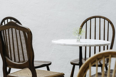 Empty chairs and table against wall at home