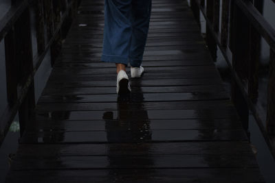 Low section of man walking in puddle at night