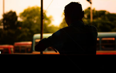 Rear view of man standing against the wall