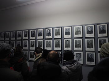 Rear view of people standing in front of window