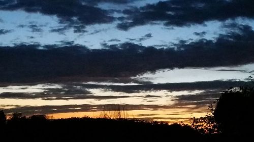 Scenic view of dramatic sky over silhouette landscape