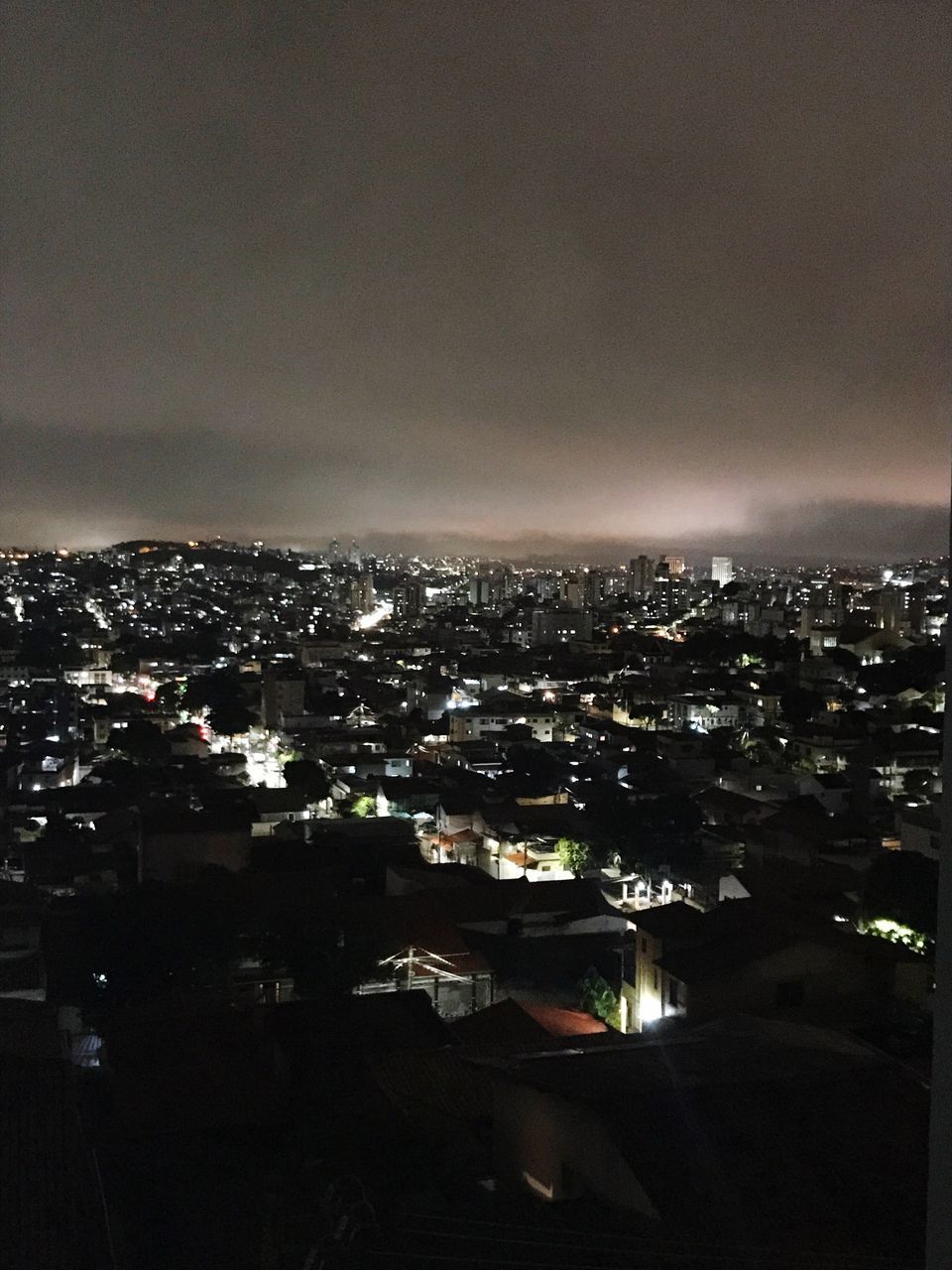 HIGH ANGLE VIEW OF ILLUMINATED BUILDINGS AGAINST SKY AT NIGHT