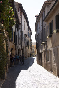 People walking on street amidst buildings in city