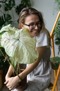 Cheerful woman with potted plants sitting at plant stores