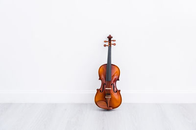 Close-up of violin against white wall