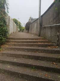 Low angle view of steps amidst buildings against sky