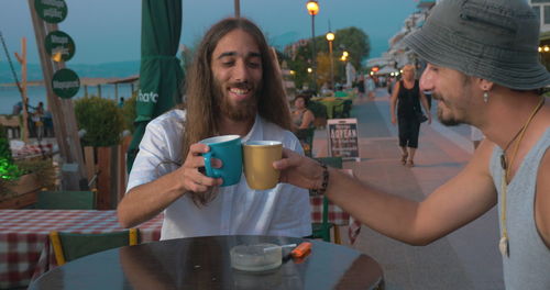 Portrait of a smiling young man drinking glass