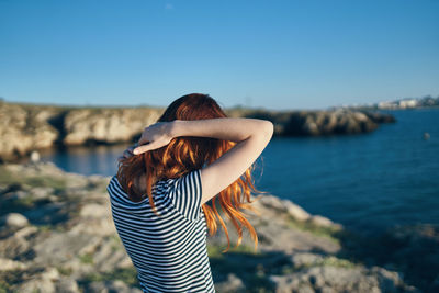 Rear view of woman standing against sky