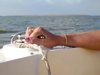 Midsection of person on sea against sky