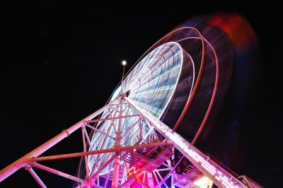 Low angle view of illuminated ferris wheel against sky at night