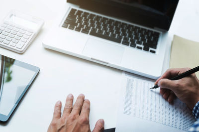 Midsection of person using laptop on table
