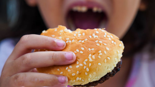 Close-up of hand holding hamburger