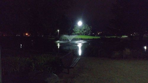 Illuminated water against sky at night