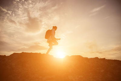 Silhouette man standing on mountain against sky during sunset