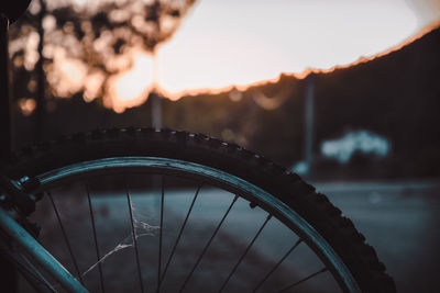 Close-up of bicycle wheel at sunset