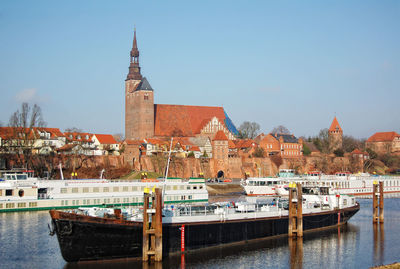 Boats in river with buildings in background