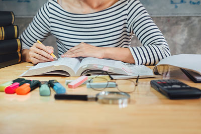 Midsection of woman reading book