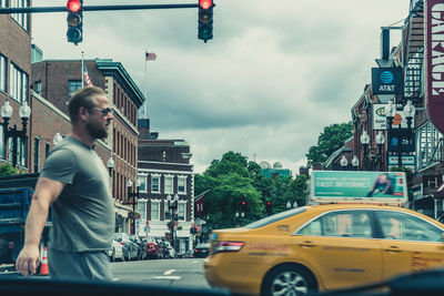 Man on city street against sky